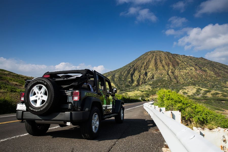 Black Jeep parked on a mountain road on Oahu under a deep blue sky